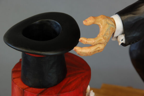 The head of a dove peeks out of the left hand sleeve of the Magician's coat.