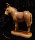 Donkey standing with his head turned to the side carved by dylan goodson