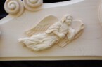 close up of one of the angels on the ornate frame
