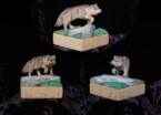 Two inch square wood carving of a wolf stepping over a log
