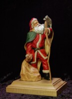 Santa Claus with a raccoon on his shoulder holding a walking stick carved by dylan goodson