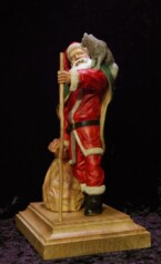 Santa Claus with a raccoon on his shoulder holding a walking stick carved by dylan goodson