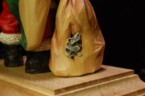 baby raccoons peeking out of a rip on Santa's bag carving done by dylan goodson