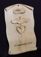 wedding plaque carved to look like a scroll with raised symbols relating to the newlyweds that it was given to.