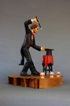 Dylan Goodson's wood carving of a magician standing on stage with wand upraised, about to conjure something out of the hat sitting on the table in front of him.